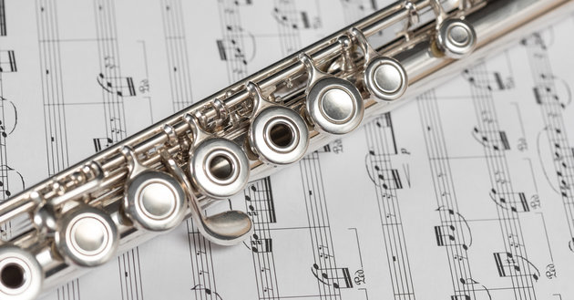 Silver flute on a musical score